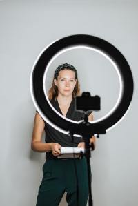 Woman with notes stands in front of a ringlight