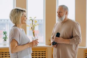 Man and woman stand and talk holding water