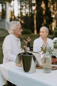Older couple sit at outdoor dinner table with champagne bucket