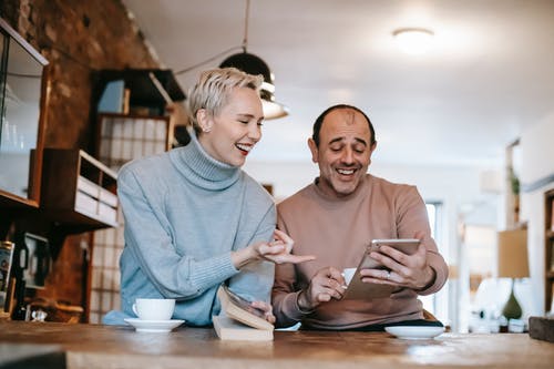 Man and woman look at tablet at coffee counter